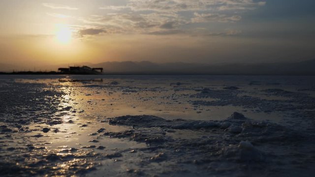 Steady shot of a sunrise reflecting on the boiling water of Danakil desert.