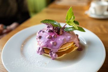 Homemade pancakes with berry sauce, mint and currant sauce
