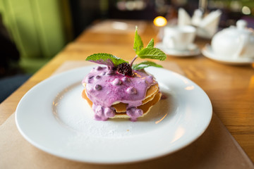 Homemade pancakes with berry sauce, mint and currant sauce