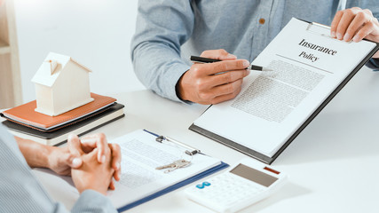 broker agent and customer holding pen, the policyholder and explain discussing for concerning mortgage loan offer for and house insurance.