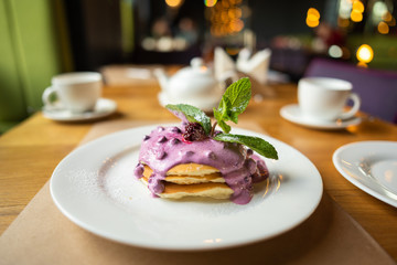Homemade pancakes with berry sauce, mint and currant sauce