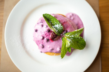 Homemade pancakes with berry sauce, mint and currant sauce