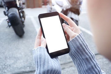  Mockup picture of business woman’s hands holding smart phone with white blank screen in modern place.