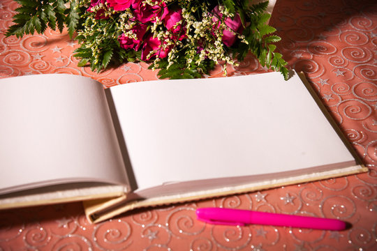 Wedding album, blank page, guest list, to do list.still life photography concept by memory and notebook.Red rose flower and Notepad book.Notebook and asters on canvas background.