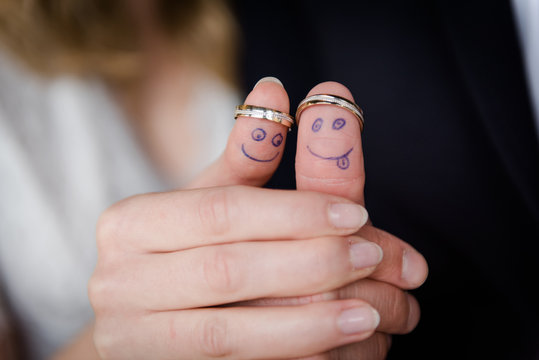 Witzige Gesichter an den Fingern mit Eheringen
