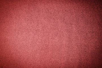 Christmas rose gold background. Red paper background. Metallic glitter noise red background, close up. 