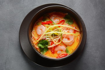 Laksa Soup – a Malaysian Coconut Curry Soup with shrimps over rice noodles topped with fresh bean spouts,cucumber, lime, red chili pepper and cilantro