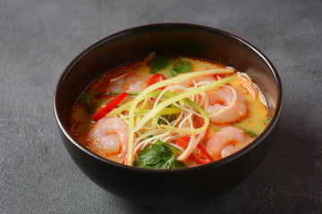 Laksa Soup – a Malaysian Coconut Curry Soup with shrimps over rice noodles topped with fresh bean spouts,cucumber, lime, red chili pepper and cilantro