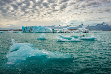 View of Glacier Lagoon Jokulsarlon with icebergs and funny shaped cloud sky, Iceland, summer