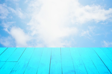 The blur cool blue sky white cloud with old Wooden table foreground.