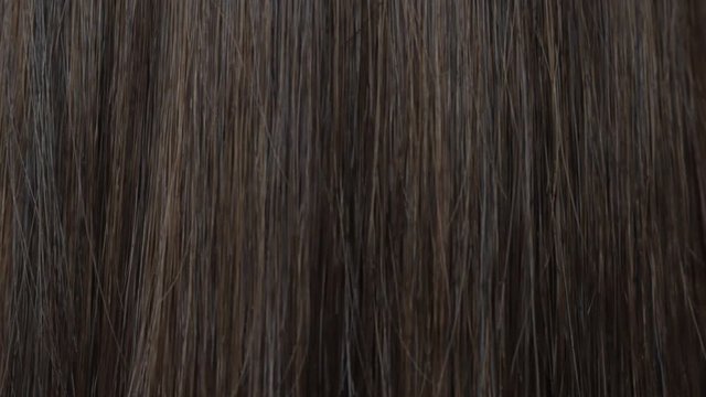 Close-up beautiful long smooth straight brown hair texture. Haircare concept, extensions, hair abstract background. HD video.