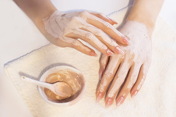 Obraz na płótnie Canvas Beautiful woman hands applying pink clay mask