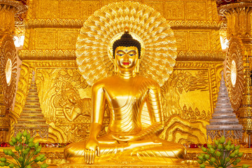 Beautiful golden buddha statue on the wall background are beautifully carved Buddhist art.