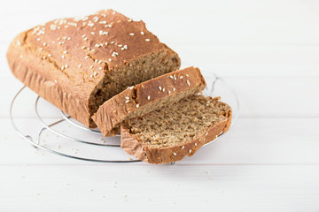 Homemade baked spelled bread on a wooden background. Slices of bread on a wire rack. Horizontal photo.