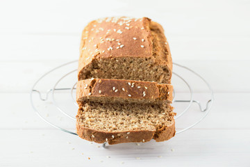 Homemade baked spelled bread on a wooden background. Slices of bread on a wire rack. Horizontal photo.