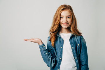 The red-haired girl smiling and points to a place for an inscription. Something on her hand. Isolated