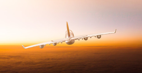 Huge two-storey passengers commercial airplane flying above clouds in sunset light. Concept of fast travel, holidays and business