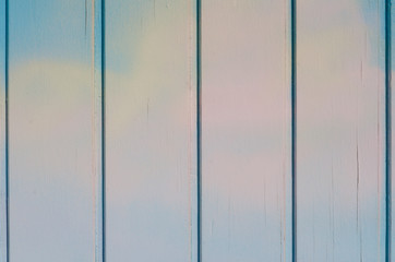 Surface of a blue wooden background with white and pink hues