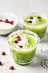 Healthy Christmas menu, vegan dessert, kiwi pomegranate coconut smoothie. Selective focus, space for text.