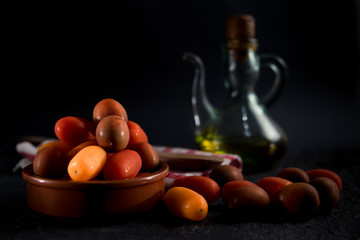 Different varieties of cherry pear tomato (Lycopersicom esculentum) on dark background.