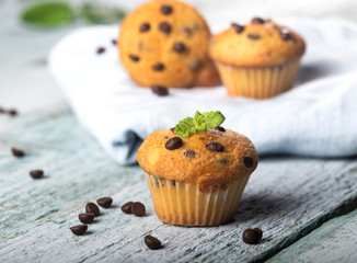 Chocolate vanilla fresh delicious muffins on blue wooden background
