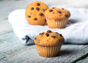 Chocolate vanilla fresh delicious muffins on blue wooden background