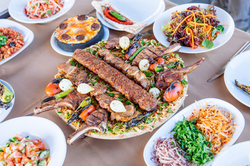 Traditional Turkish Adana kebab or kebap meat food, appetizers, raki and salgam on table from top view in turkish restaurant.	