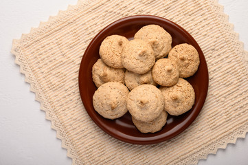 Almond biscuits on a plate on a linen napkin. Top view