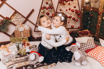 Close up portrait of cheerful happy cute caucasian girls in merry christmas decorated holiday cozy...