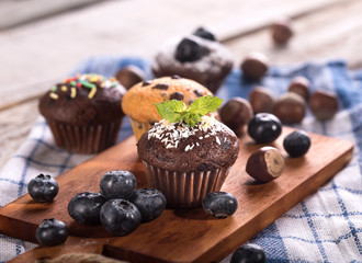 Blueberry and chocolate muffins on white wooden background