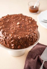 Chocolate cake with nuts and caramel on a light background.