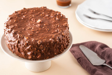 Chocolate cake with nuts and caramel on a light background.