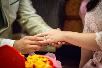 Obraz na płótnie Canvas Wedding rings. He Put the Wedding Ring on Her. Close up Groom Put the Ring on bride. thai wedding ceremony and thai wedding decoration. Groom Put the Ring on bride's finger.