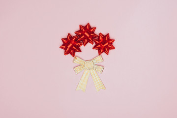 top view of red and golden bows isolated on pink