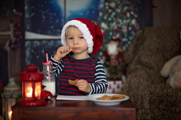 Obraz na płótnie Canvas Sweet blonde toddler boy, writing letter to Santa, wishing presents