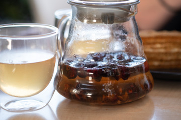 Fruit tea in a transparent teapot and mug.