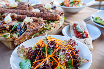 Traditional Turkish Adana kebab or kebap meat food, appetizers, raki and salgam on table from top view in turkish restaurant.	