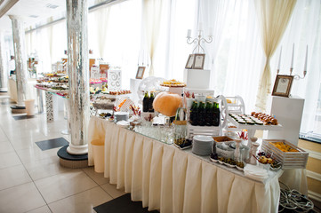 Dessert table of delicious snacks on wedding reception.