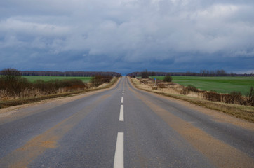 empty road between two green fields