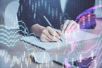 Forex graph on hand taking notes background. Concept of research. Multi exposure