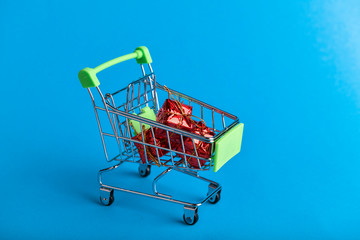 Christmas presents shopping concept. Basket and christmas accessories. Christmas basket with presents. Onlain shopping. On a blue background. place for writing.