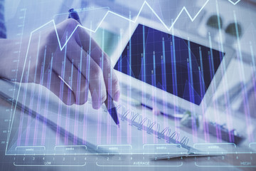 Financial forex graph drawn over hands taking notes background. Concept of research. Multi exposure