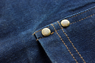 Close-up Blue Denim or jeans and metal buttons surface and texture background.