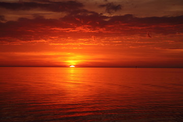 Fototapeta na wymiar Crimson red sunset on the beach in Florida in winter