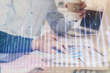 Multi exposure of chart with man typing on computer in office on background. Concept of hard work.