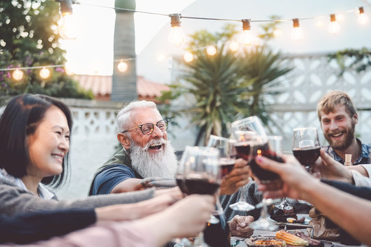 Happy Family Dining And Toasting Red Wine Glasses Outdoor - People With Different Ages And Ethnicity Having Fun In Barbecue Dinner Party - Parenthood Youth And Elderly Weekend Activities Concept