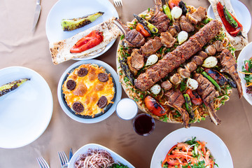 Traditional Turkish Adana kebab or kebap meat food, appetizers, raki and salgam on table from top view in turkish restaurant.	