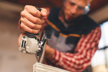 Fototapeta premium Close up of a man using grinder. Selective focus on hand and grinder,