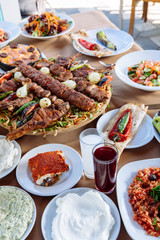 Traditional Turkish Adana kebab or kebap meat food, appetizers, raki and salgam on table from top view in turkish restaurant.	