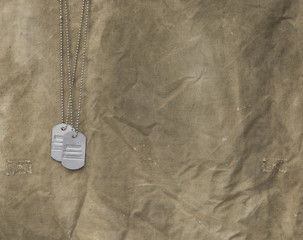 military dogtag on a worn green military  cloth background